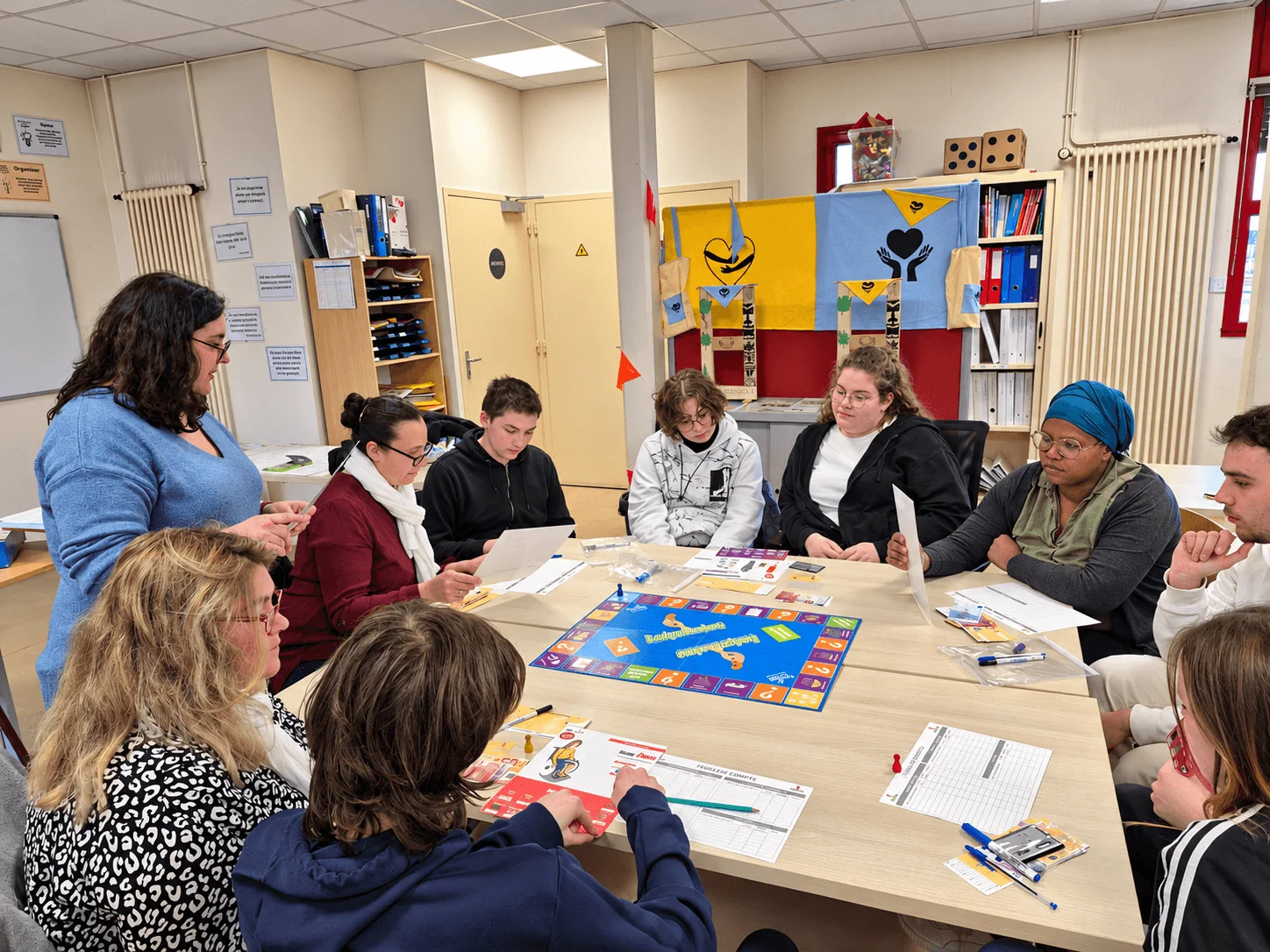 Atelier collectif avec un jeu éducatif et des participants autour d’une table